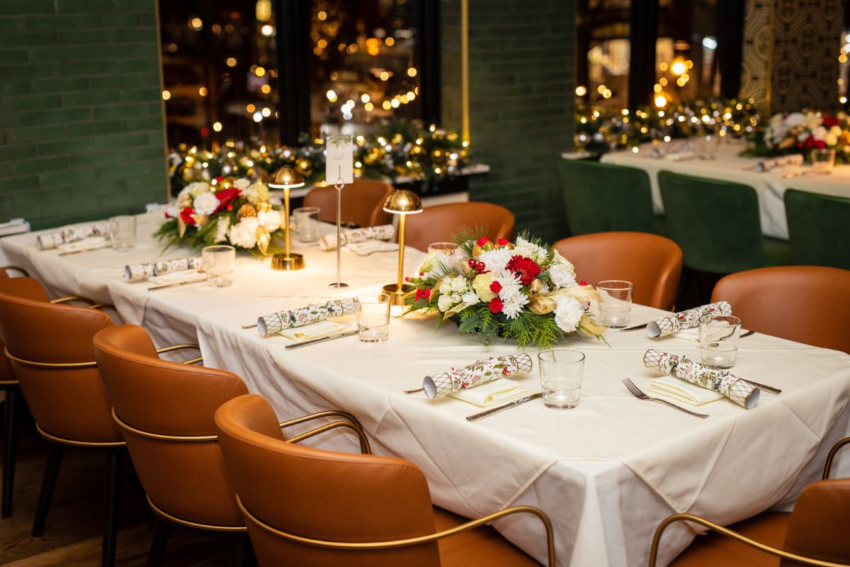 Tablescape set for a holiday party at The Bellevue, featuring red, white and green flowers and Christmas crackers